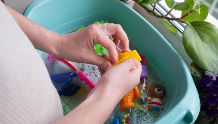 Washing plastic kids toys from microbes and dirt. Children hygiene concept