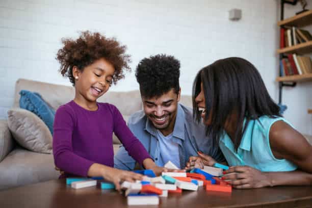 Portrait of an african american family having fun playing jenga at home.