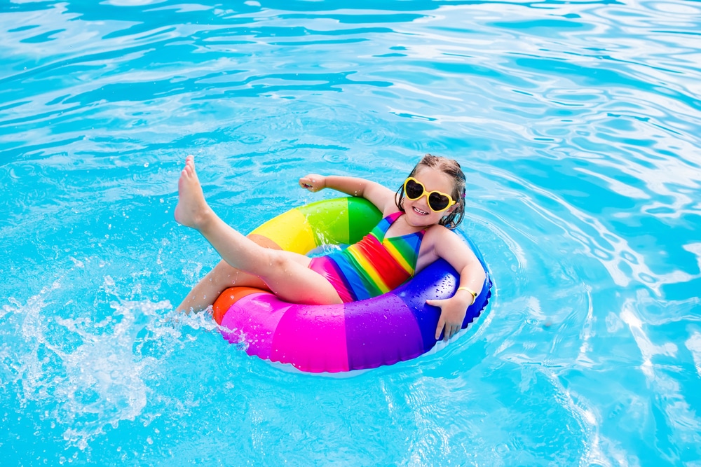 Happy,Little,Girl,Playing,With,Colorful,Inflatable,Ring,In,Outdoor