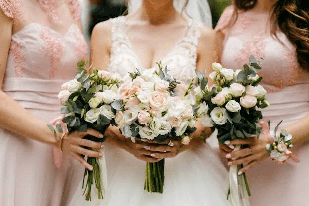 Three bridesmaids holding bouquets of birth flowers