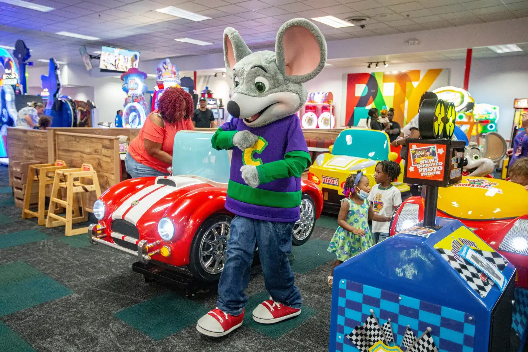 Mouse in car with toy car in background at Chuck-E-Cheese: The Game Time