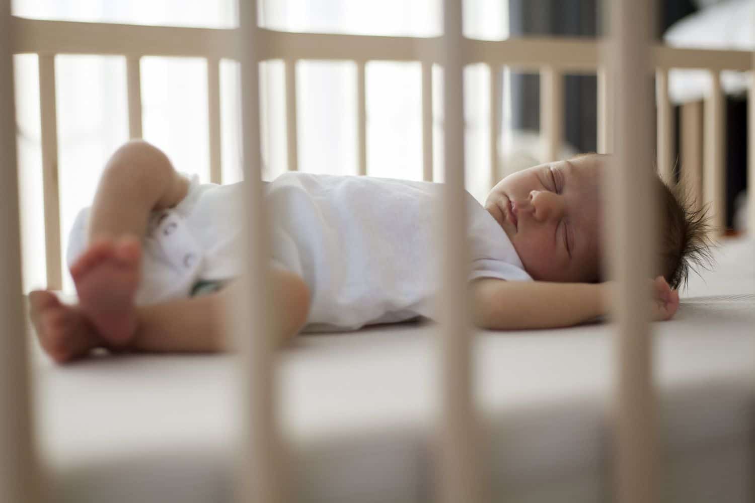 A serene baby sleeping soundly in a crib, following the Do's and Don'ts for a safe sleep environment