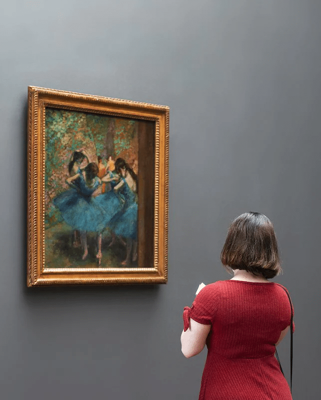 a painting of dancers in a frame, adding elegance to the decor."