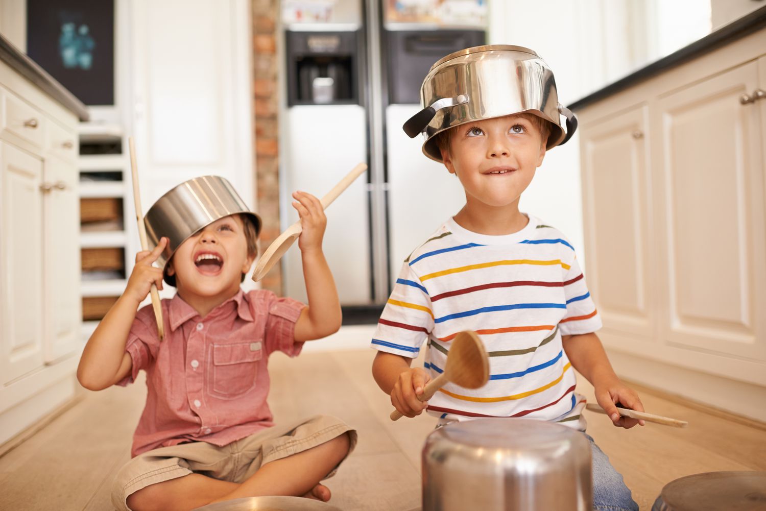 Two young boys joyfully playing with pots and pans, creating music and laughter. Help Your Neighbor