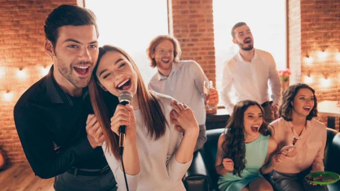 A lively group of people singing and enjoying themselves at a bar during a Karaoke Night