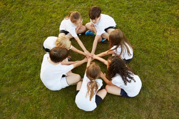 Children sitting in a circle on grass