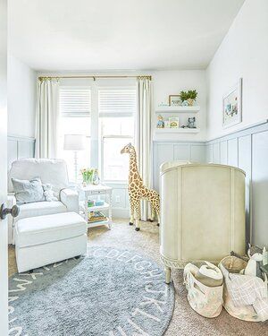 A baby's room with a giraffe on the rug