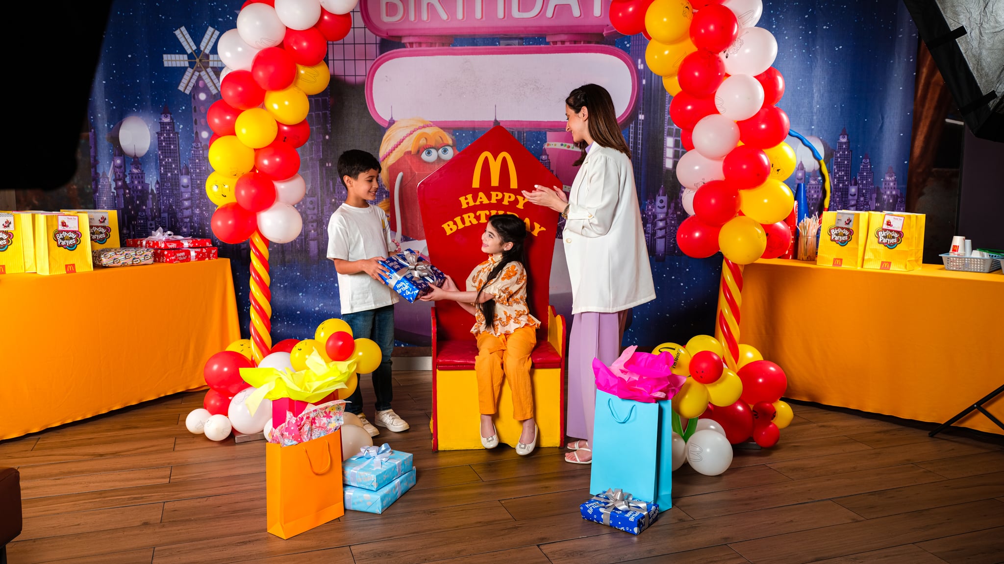 Colorful birthday party with balloons, cake, and Happy Meals from Mc Donalds
