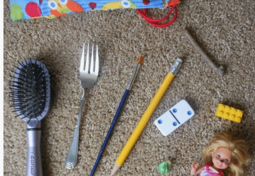 Assorted items including a doll's purse, scissors, toothbrush, and others in a Kids' Mystery Bag Design Adventure Game