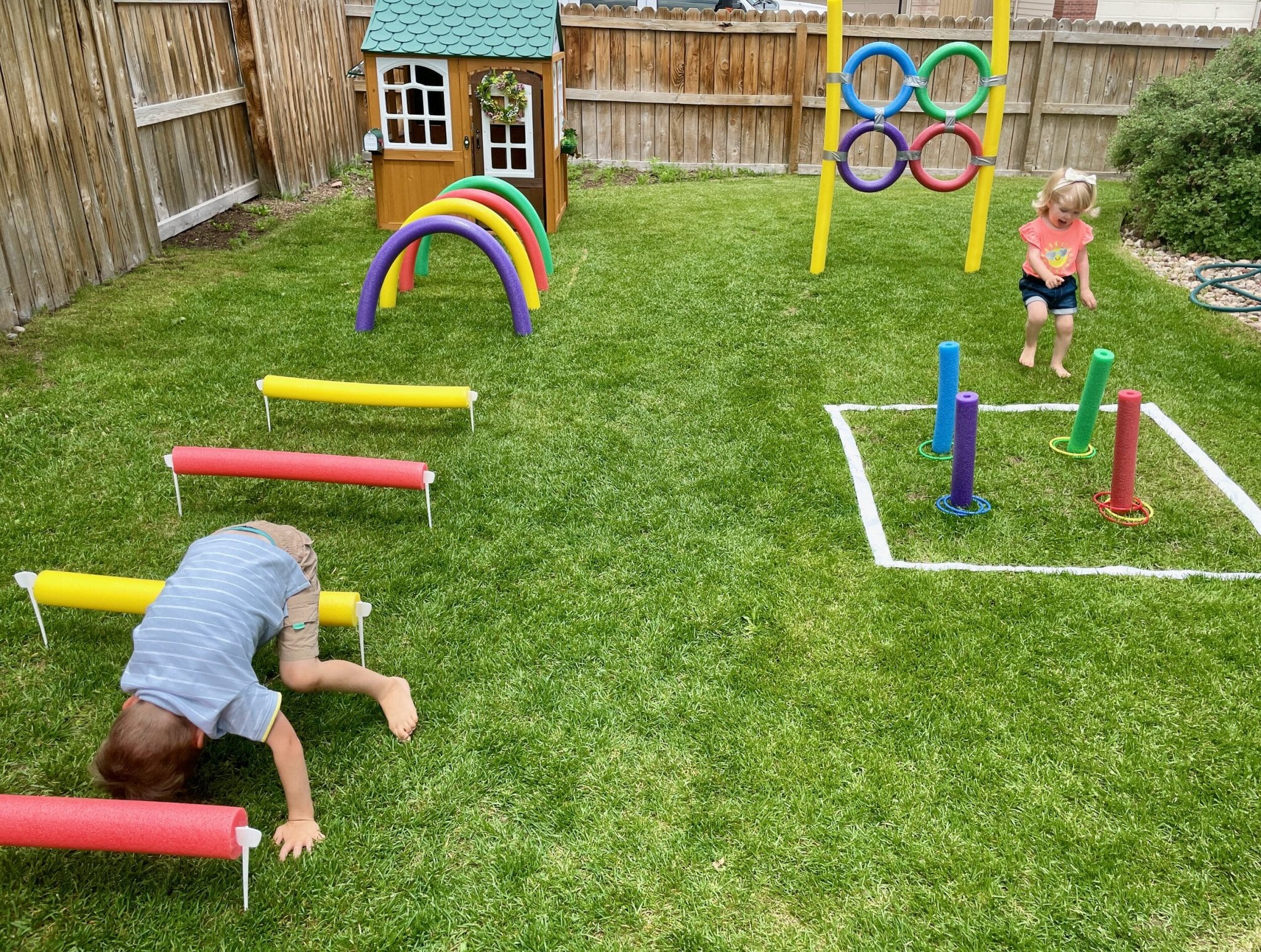 A child joyfully playing on a wooden play set in a backyard, enjoying an obstacle course adventure