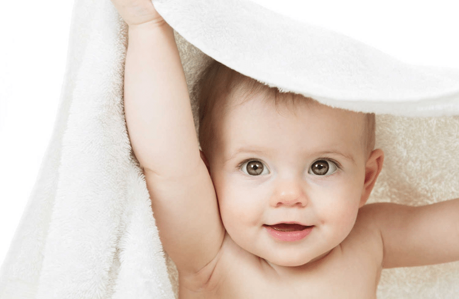 A baby hidden under a white towel