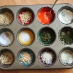 A muffin pan filled with colorful ingredients, perfect for baking or creating art with textured finger paintings