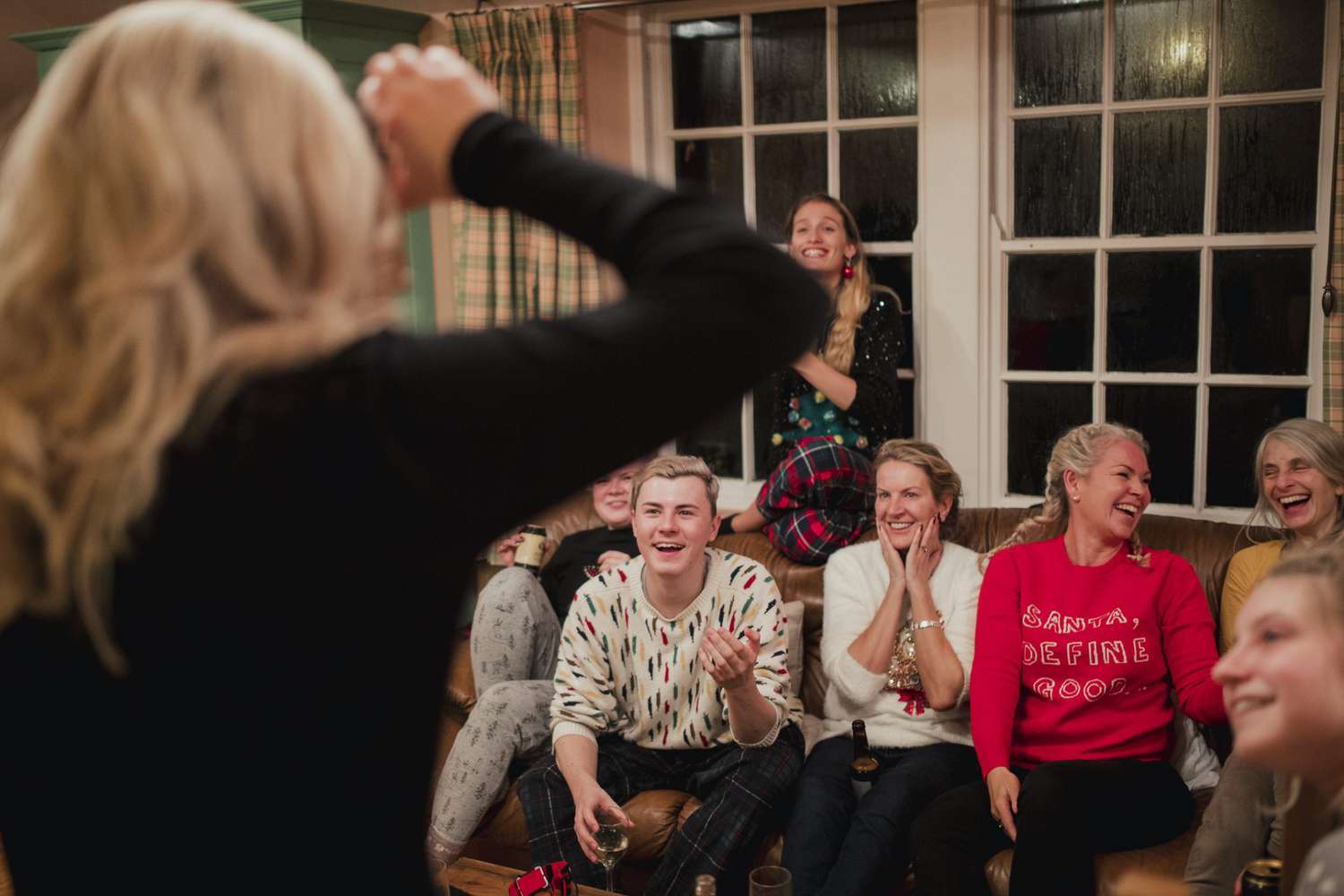 A woman capturing a moment with her friends in a cozy living room
