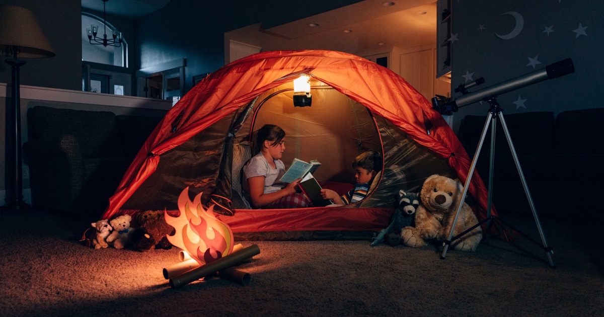 Girl and Boy Reading while Camping Indoors