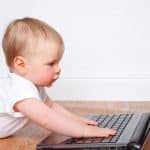 a toddler trying to operate a laptop