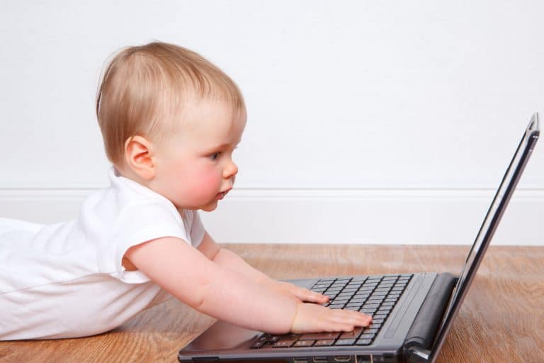 a toddler trying to operate a laptop
