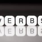 White cubes spell out the word "verbs" - a visual representation of the concept of verbs.