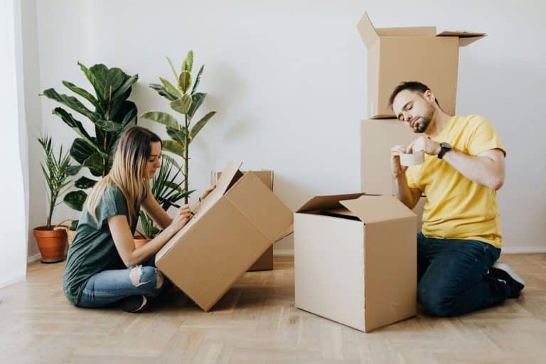 A couple preparing their moving boxes for moving into a small home